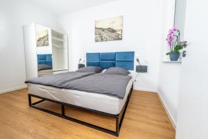 Schlafzimmer mit einem großen Bett mit blauem Kopfteil in der Unterkunft Apartment Weingut Dr Hermann I in Erden