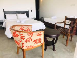 a hotel room with a bed and a chair and a chair at Kobbekaduwa Bungalow in Kandy