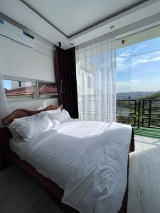 um quarto com uma cama e uma grande janela em Prayer Mountain Cove em Kampala