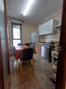 cocina con mesa y sillas y cocina con fogones en Hostal en Mieres