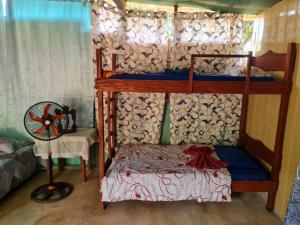 een slaapkamer met 2 stapelbedden en een ventilator bij Ceiba Ganadito in Drake