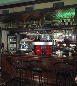 a bar with red vases and bar stools at Motels21 in Sersheim