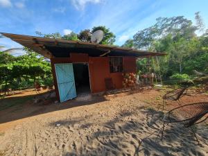 een klein huis aan de kant van een onverharde weg bij Ceiba Ganadito in Drake