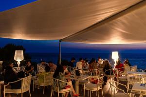 a group of people sitting at tables under a tent at Grand Hotel Santa Maria in Santa Maria di Castellabate