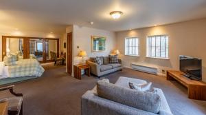 a living room with a bed a couch and a tv at The Marcliffe Hotel and Spa in Aberdeen