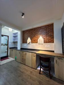 cocina con encimera y pared de ladrillo en Shahi Studio Apartment en Pātan