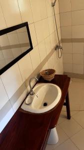 a bathroom with a sink and a mirror at Campement Jamarek in Kafountine