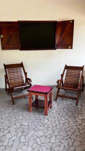 two chairs and a table in a room at Campement Jamarek in Kafountine