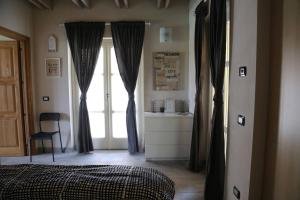 ein Schlafzimmer mit einem Bett und einem großen Fenster in der Unterkunft La Corte dei Grappoli in Viarigi