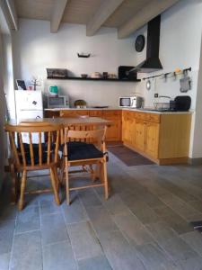 eine Küche mit Holzschränken sowie einem Tisch und Stühlen in der Unterkunft La Corte dei Grappoli in Viarigi