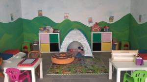 uma sala de jogos para crianças com uma casa de brinquedos em La Corte dei Grappoli em Viarigi