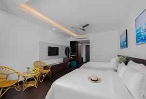 ein weißes Zimmer mit einem Bett, einem Tisch und Stühlen in der Unterkunft Hoang Yen Boutique Hotel in Dien Ban