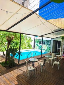 un patio con mesas y sillas y una piscina en Fuxia Jungle Hostel en Mendoza
