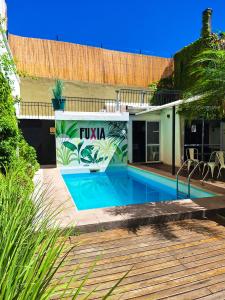 a swimming pool in front of a house at Fuxia Jungle Hostel in Mendoza