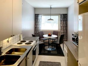 a small kitchen with a sink and a table at Apartment Ryti in Kokkola