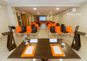 una sala de conferencias con mesas y sillas de color naranja y negro en Hoteles Paraiso PIURA en Piura