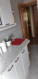 a kitchen with a white counter top with a red sink at Habitación LCV in Madrid