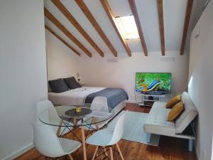 a bedroom with a bed and a table and a tv at Charm studio in Bombarral