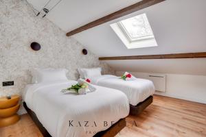 two beds in a attic room with a window at KAZA BELLA - Maisons Alfort 7 - Large modern family flat in Maisons-Alfort +10 photos