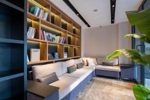 a living room with a couch and bookshelves at FLY POINT AIRPORT HOTEL in Arnavutköy
