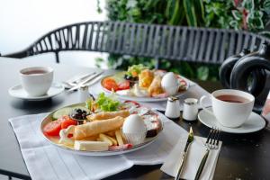 a table with two plates of food and two cups of coffee at FLY POINT AIRPORT HOTEL in Arnavutköy