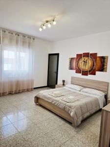 Vincenti's House Comiso في كوميزو: غرفة نوم بسرير كبير في غرفة بيضاء