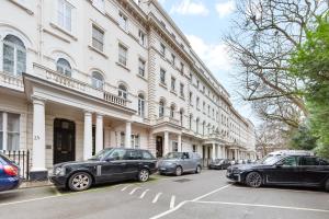 a group of cars parked in front of a building at Heart of London Luxury, 1 Min Walk from Paddington Station, Beautiful Apartment with Smart TV in London