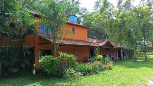 ペネドにあるHostel Centro Hípico Quintalのバルコニー付きのオレンジハウスです。