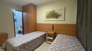 una camera d'albergo con due letti e un bagno di Apartamento 3 Quartos Thermas Paradise a Rio Quente