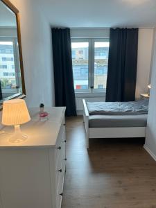 een kamer met een bed, een bureau en ramen bij Ferienwohnung Hansetraum Lübeck in Lübeck