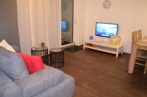 sala de estar con sofá y TV de pantalla plana en Residenz am Bodensee, en Friedrichshafen