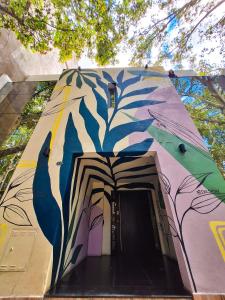 um edifício com uma pintura de árvores sobre ele em Fuxia Jungle Hostel em Mendoza