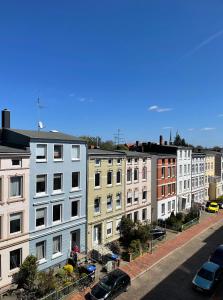 a row of buildings on a street with parked cars at Ferienwohnung Hansetraum Lübeck in Lübeck