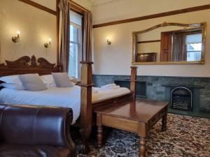 1 dormitorio con cama, espejo y silla en Keswick Park Hotel en Keswick