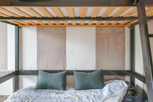 a bed with two blue pillows in a room at Appartement vue mer 50m de la plage in Saint-Hilaire-de-Riez