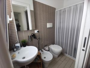 ein Badezimmer mit einem weißen Waschbecken und einer Toilette in der Unterkunft Villetta Luxury Lunady vicino al mare in Marina di Ragusa