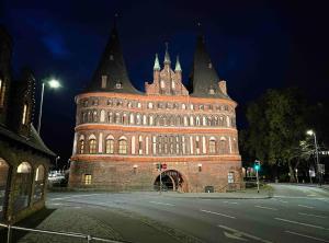 een groot gebouw wordt 's nachts verlicht bij Ferienwohnung Hansetraum Lübeck in Lübeck