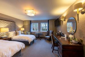 a hotel room with two beds and a desk at The Marcliffe Hotel and Spa in Aberdeen