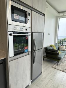 a kitchen with a stainless steel refrigerator and a microwave at Prayer Mountain Cove in Kampala