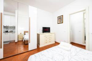 una camera da letto bianca con un letto e uno specchio di [Firenze] New and Elegant Suite a Firenze Altre 8 foto