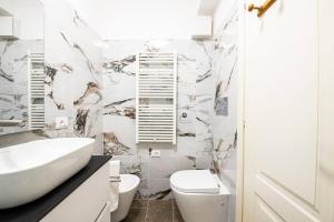 un bagno bianco con lavandino e WC di [Firenze] New and Elegant Suite a Firenze