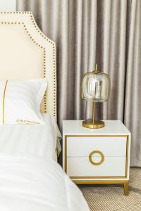 a bed with a night stand with a lamp on it at BWAGAmoyo by Enamour in Yombo