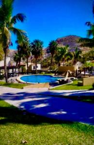 uma piscina com palmeiras e uma montanha em Casa bella Loma encantada em San José del Cabo