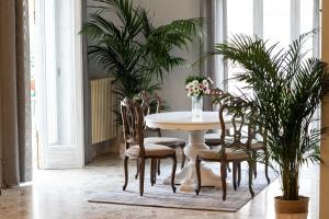 jadalnia ze stołem, krzesłami i roślinami w obiekcie Rudiae Boutique w mieście Lecce
