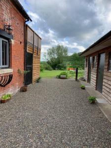 a walkway between two brick buildings with plants at Beautiful converted Coach house for two in Hoptonheath