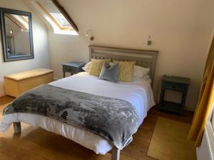 a bedroom with a large bed and a mirror at Beautiful converted Coach house for two in Hoptonheath