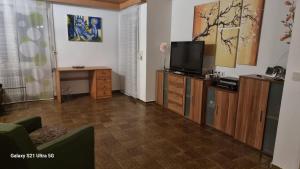 a living room with a television on a wooden cabinet at Haus Zeller in Klettgau