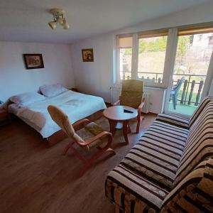 a bedroom with a bed and a table and a couch at Pokoje u Danuty in Piwniczna-Zdroj