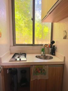 encimera de cocina con fregadero y ventana en SUITE OCEAN VIEW - PLAYA en Tolú