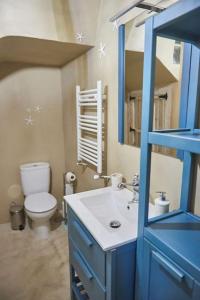 Baño azul con aseo y lavamanos en Alojamiento y Visita a Bodega Miradorio Incluida, en Casasola